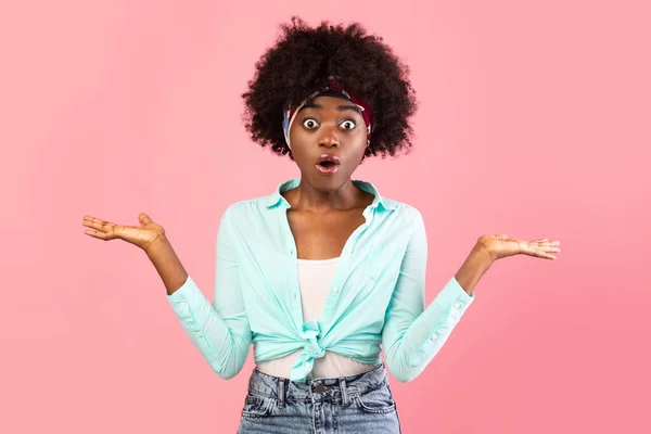 Chocado afro-americano jovem mulher encolhendo ombros sobre fundo rosa — Fotografia de Stock