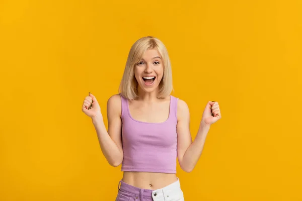 Concepto de logro. Mujer eufórica celebrando emocionalmente el éxito, levantando puños y exclamando con emoción —  Fotos de Stock