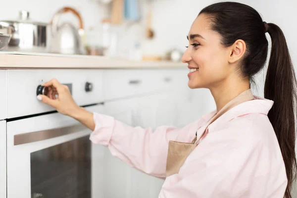 Donna che utilizza fornello cottura cibo in cucina — Foto Stock