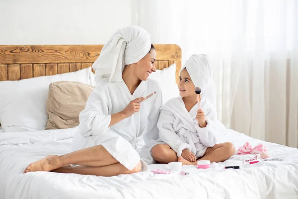 Mãe bonita e filha em roupões de banho segurando escovas — Fotografia de Stock