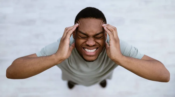 Black Man Having Headache Suffering From Pain Standing Indoors, Top-View — Stock Photo, Image