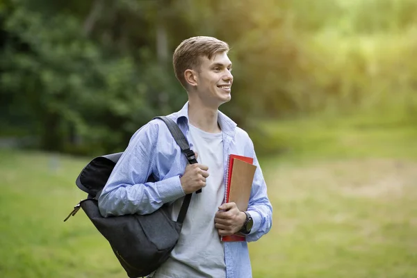 Retrato ao ar livre de cara estudante adolescente atraente com mochila e cadernos de trabalho — Fotografia de Stock