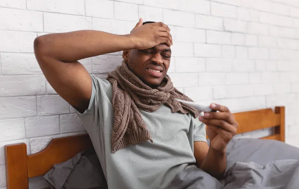 Enfermo negro chico tener fiebre sentado en la cama en interiores — Foto de Stock