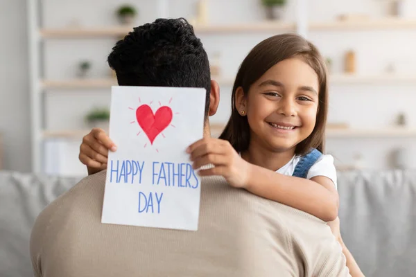 Hijita saludando a papá joven con tarjeta — Foto de Stock