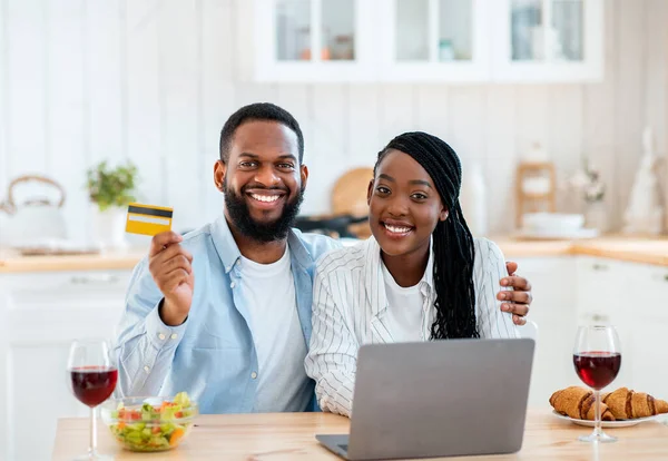 Porträt fröhlicher schwarzer Liebhaber mit Laptop und Kreditkarte in der Küche — Stockfoto