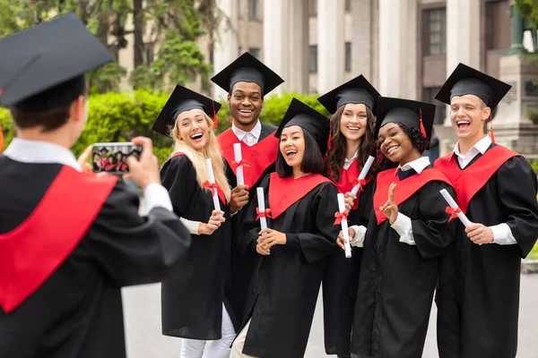 Estudantes internacionais positivos comemorando a formatura, tirando fotos — Fotografia de Stock