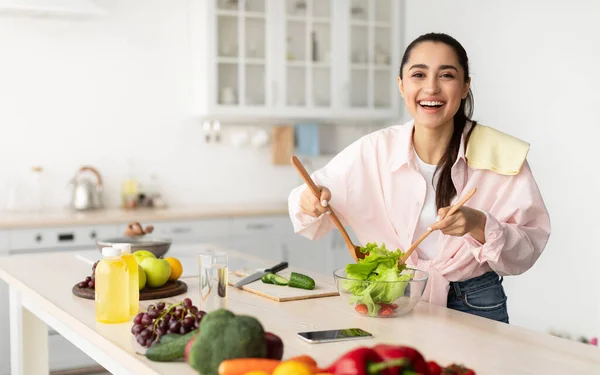 Portrait of smiling young woman cooking fresh salad