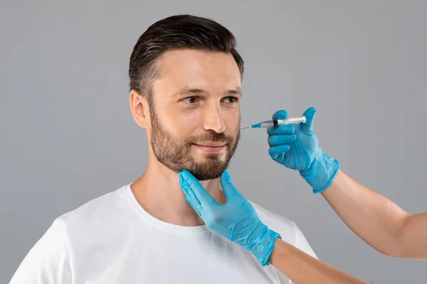 Hombre guapo recibiendo inyecciones de belleza en el salón — Foto de Stock