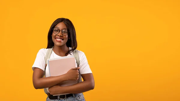 Estudiante afroamericana positiva con cuaderno en amarillo — Foto de Stock