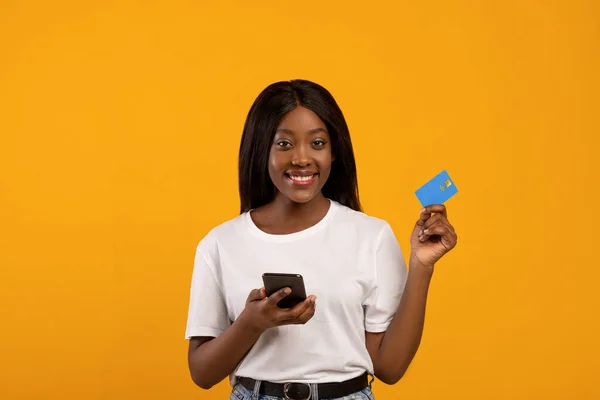 Mujer bastante negro con teléfono inteligente y tarjeta de crédito — Foto de Stock