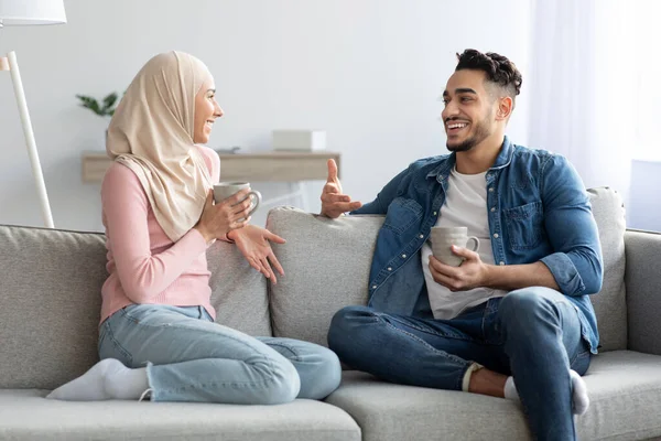 Junges muslimisches Paar trinkt Tee und redet zu Hause — Stockfoto