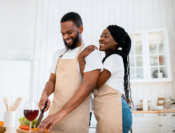 Romantyczny lunch. Happy Black żona przytulanie mąż podczas gotowania żywności razem — Zdjęcie stockowe