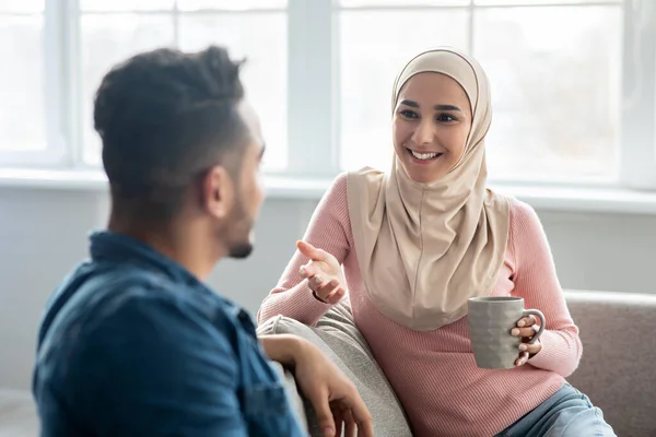 Allegro signora in hijab avendo conversazione con il marito — Foto Stock