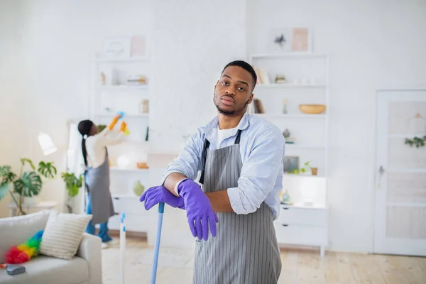 Zu viel Hausarbeit. Müde schwarz kerl gefühl gelangweilt von putzen haus mit seine freundin, free space — Stockfoto