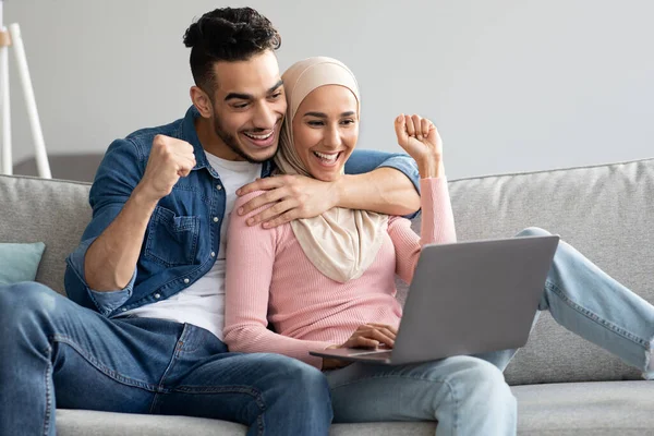 Glad arab par med laptop höja knytnävarna upp — Stockfoto