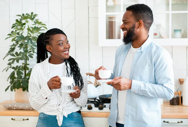 Codzienne życie par. szczęśliwy czarny mężczyzna i kobieta pijąc kawę w kuchnia — Zdjęcie stockowe