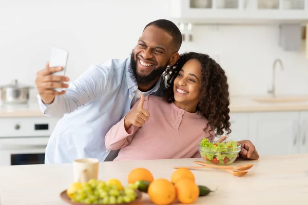 Fröhlicher schwarzer Vater macht Selfie mit süßer Tochter — Stockfoto