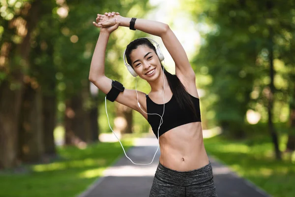 Athletische asiatische Frau in Sportbekleidung macht Dehnübungen im Freien, Training im Park — Stockfoto