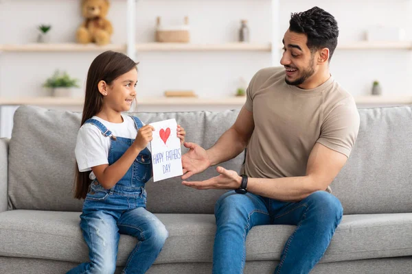 Fille mignonne saluant excité jeune papa avec carte à la main — Photo