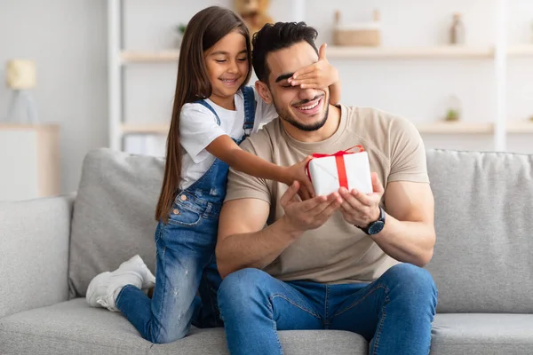 Menina comemorando o dia dos pais, cumprimentando pai animado com caixa — Fotografia de Stock