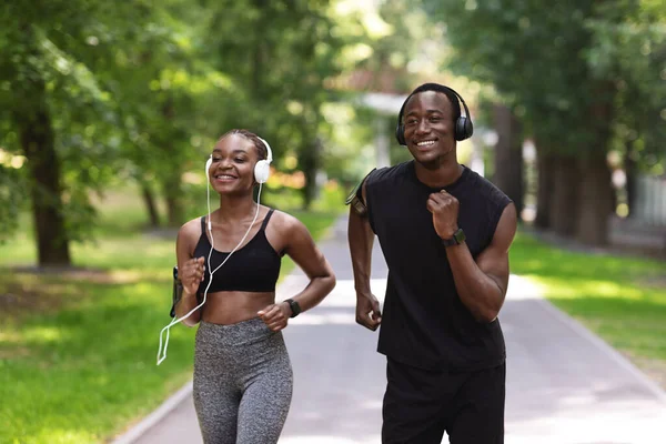 Mattina attiva. Aporty africano coppia running in estate parco insieme — Foto Stock