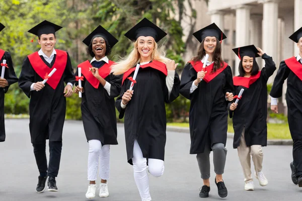 Grupo multirracial emocional de estudantes que correm por campus universitário — Fotografia de Stock