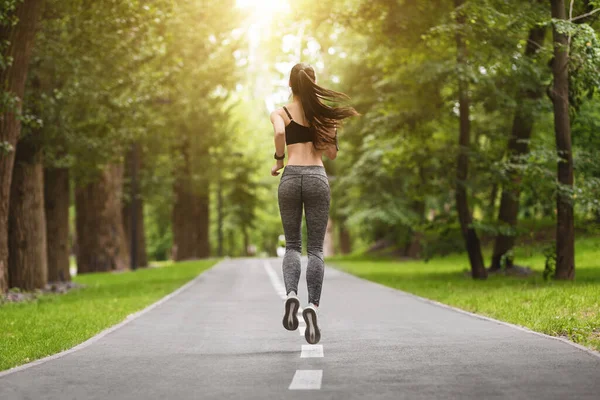 Vista posteriore di Fit Slim Female Runner Jogging nel parco della città estiva — Foto Stock