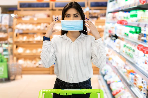 Arabic Woman Wearing Protective Face Mask Standing In Supermarket