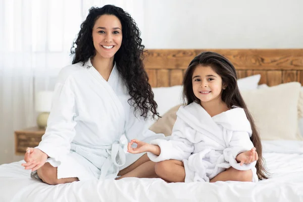 Bionda madre e figlia in accappatoi meditando — Foto Stock