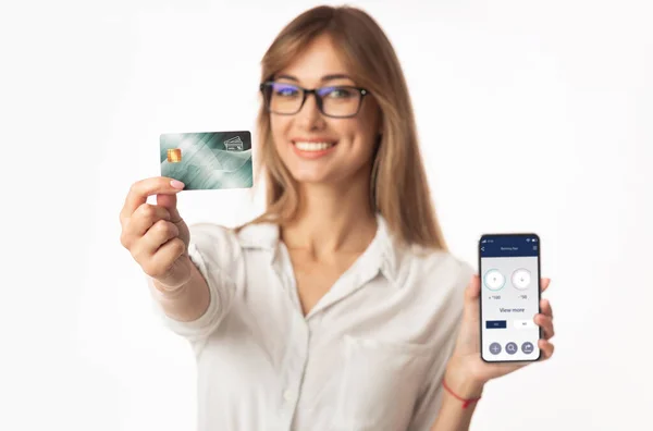 Hübsche junge Frau zeigt Kreditkarte und Banking-App — Stockfoto