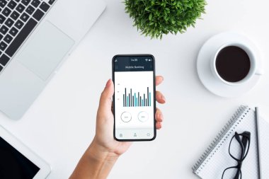 Ticaret uygulaması ve ofis içi kullanıma açık cep telefonu tutan kadın eller.