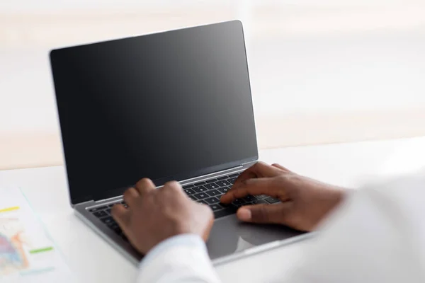 Moderne geneeskunde op covid-19. Afro-Amerikaanse mannelijke arts met behulp van laptop computer met leeg scherm — Stockfoto