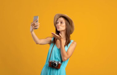 Akıllı telefondan selfie çeken oldukça mutlu bir genç bayan gezgin.