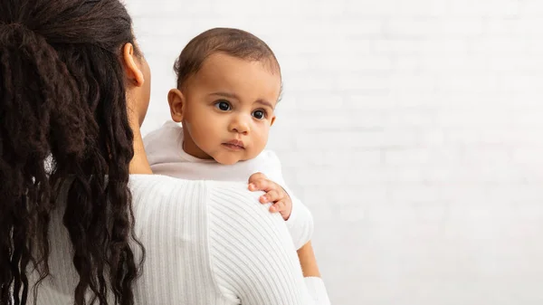 Afrikansk amerikansk mor doserar med söt baby över grå vägg — Stockfoto