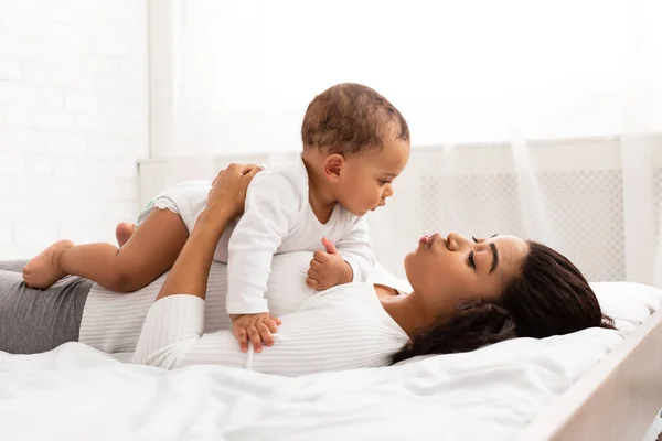 Mutlu Siyahi Anne Yatakta Bebekle Oynuyor — Stok fotoğraf