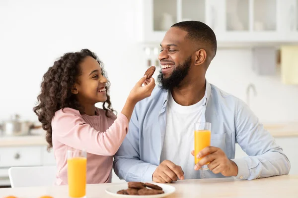 Glada afrikanska amerikanska flicka mata pappa med kaka — Stockfoto