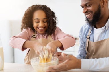 Mutfakta hamuru karıştıran mutlu afro aile