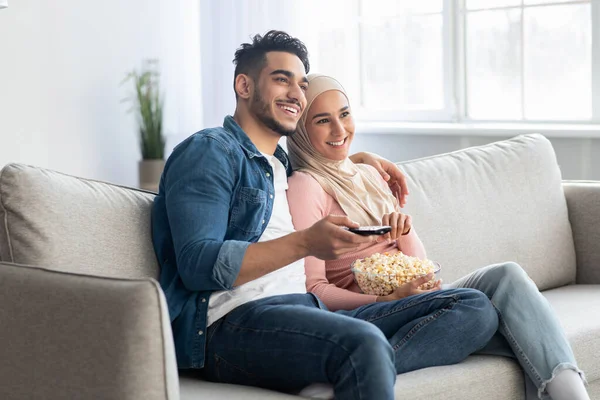 Gioioso arabo coppia guardando la TV insieme a casa — Foto Stock