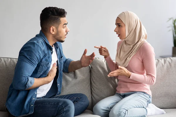 Емоційний мусульманський чоловік і жінка, що бореться вдома — стокове фото