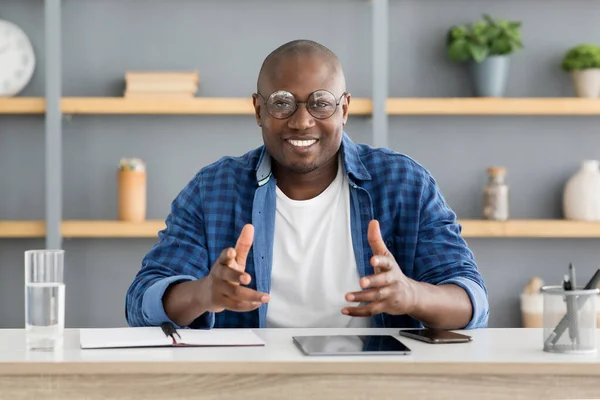 Šťastný africký americký obchodní trenér mluví a gestikuluje na kameru, pracuje v interiéru domácí kanceláře — Stock fotografie
