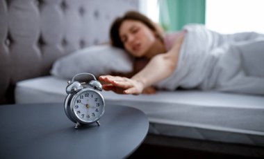 Genç bir kadın uyanıyor ve çalar saati kapatıyor, sabahları yatağa uzanıyor, işe gitmek istemiyor, uzayı kopyalıyor.