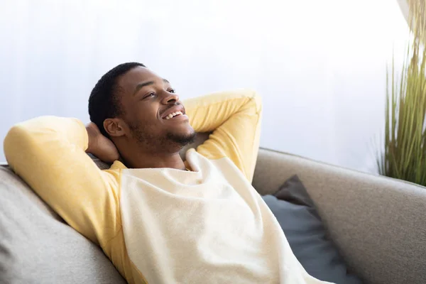 Primer plano de chico negro relajándose en el sofá en casa —  Fotos de Stock