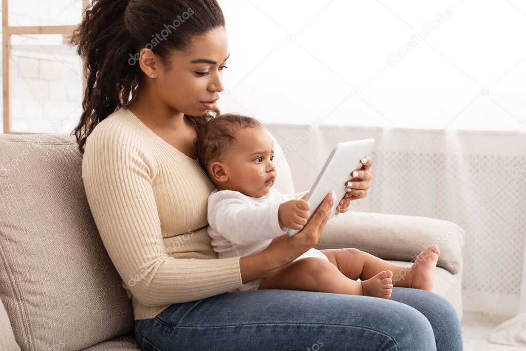 Young African Mother And Her Baby Using Tablet At Home