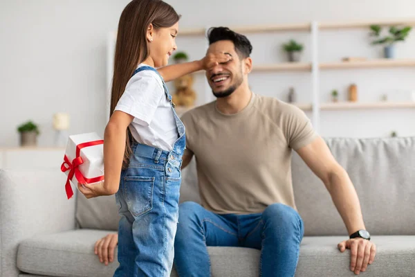 Menina celebrando o dia dos pais, cumprimentando pai animado com caixa — Fotografia de Stock