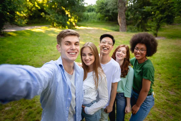 Groep van multi-etnische tiener vrienden praten selfie buiten in park — Stockfoto