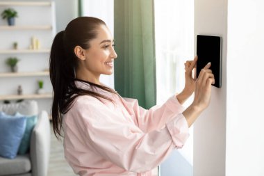 Akıllı duvar ev kontrol sistemi kullanan kadın