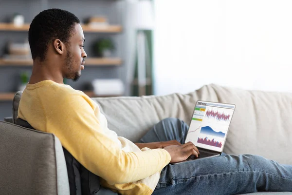 Συγκεντρωμένος μαύρος τύπος που εμπορεύεται στην αγορά online, χρησιμοποιώντας φορητό υπολογιστή — Φωτογραφία Αρχείου
