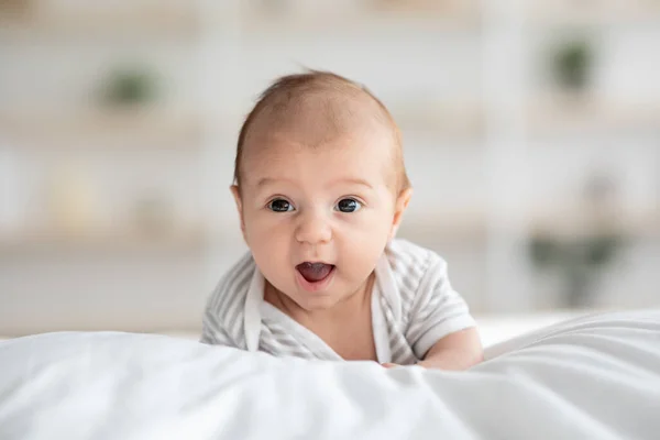 Close-up schot van schattig zuigeling baby liggend in bed op zijn buik — Stockfoto