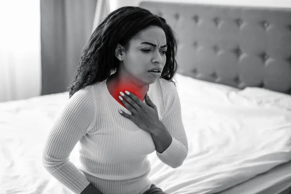 Young black woman coughing, suffering from sore throat