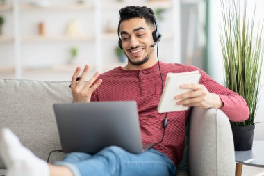 Çevrimiçi eğitime evde katılan pozitif Arap adam.